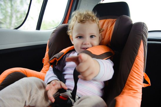 Cute baby enjoying a road trip in a baby car seat